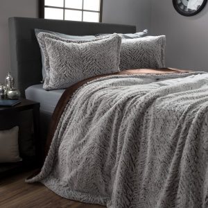 Una bonita cama con una colcha de pelo gris.
